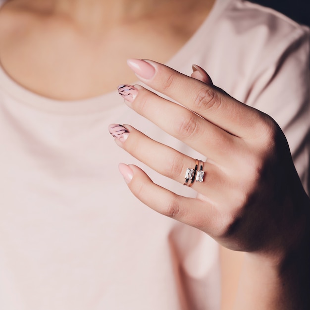 Sluit omhoog van handen van vrouw die de ring met diamant tonen. Ze is verloofd.