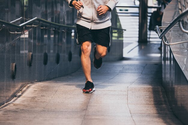 Sluit omhoog van Jonge atletische mensenjogging op stadsbrug bij de ochtend.