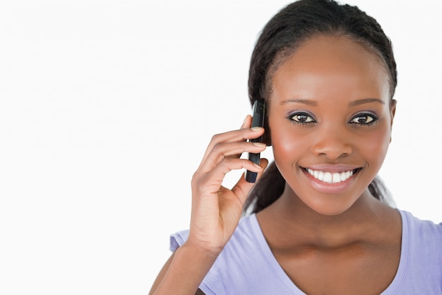 Sluit omhoog van jonge vrouw op de telefoon op witte achtergrond