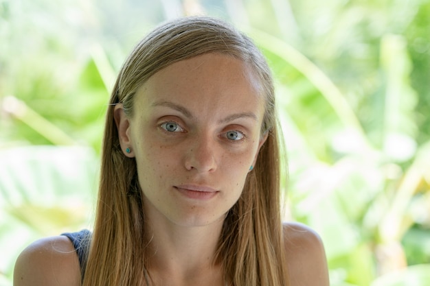 Sluit omhoog van Kaukasisch meisjesgezicht. Portret van een jonge vrouw in de natuur