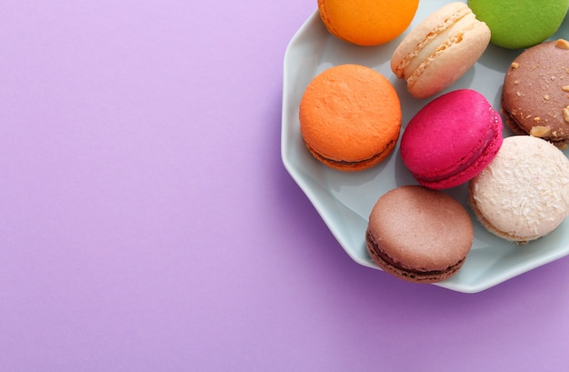 Sluit omhoog van kleurrijke Franse bitterkoekjes op blauw bord