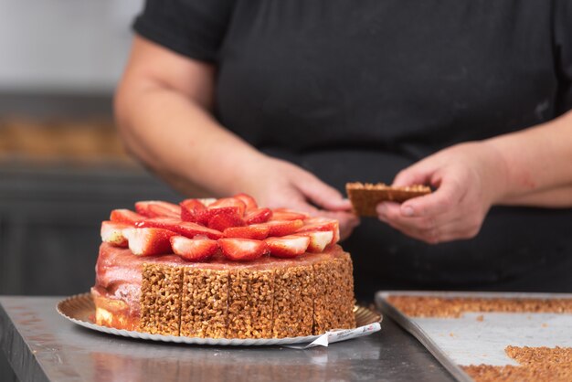 Sluit omhoog van professionele banketbakker die een heerlijke cake in de patisserie maken.