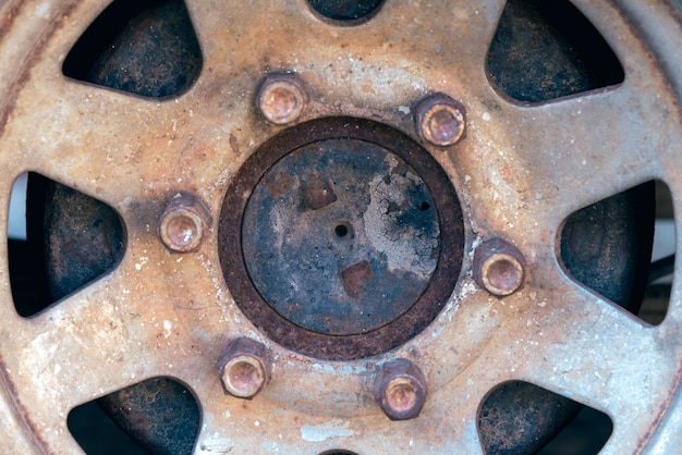 Sluit omhoog van roestige wieldop van verlaten auto.