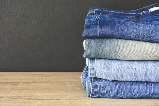 Sluit omhoog van stapel gevouwen denimjeans op houten lijst