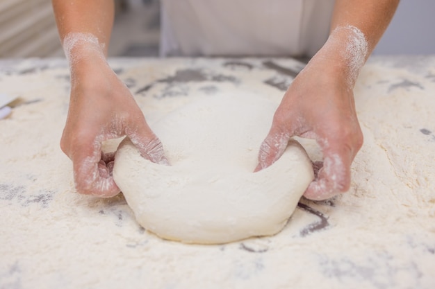 Sluit omhoog van vrouw die Pizzadeeg kneden.