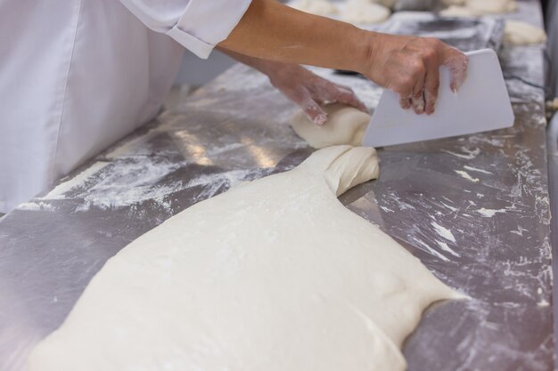 Sluit omhoog van vrouw die Pizzadeeg kneden.