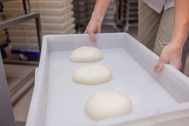 Sluit omhoog van vrouw die Pizzadeeg kneden.