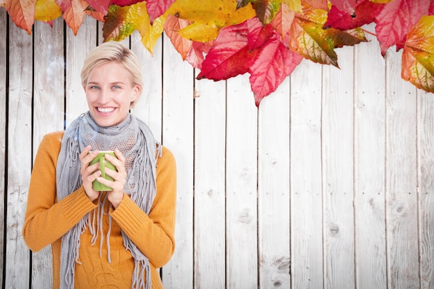 Sluit omhoog van vrouw het drinken van een kop tegen het patroon van de herfstbladeren