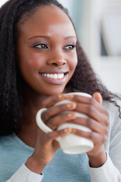 Sluit omhoog van vrouw op bank die koffie hebben