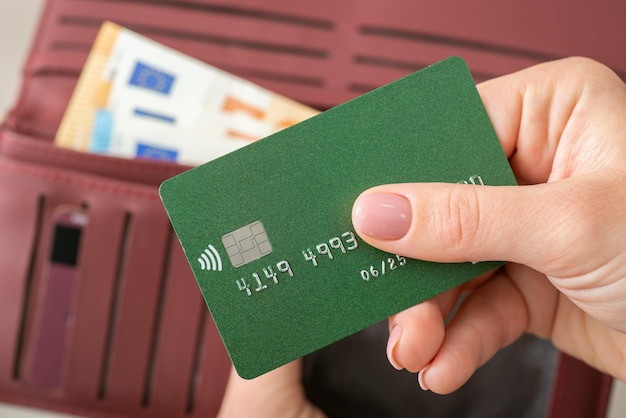 Sluit omhoog van vrouwenhand die groene creditcard houden