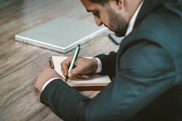 Foto sluit omhoog van zakenman writing in notebook