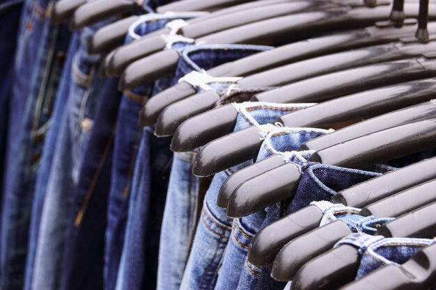 Sluit omhoog Vele jeans die op rek hangen