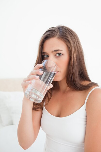 Sluit omhoog, vrouw die een drank van een glas neemt terwijl vooruit het kijken