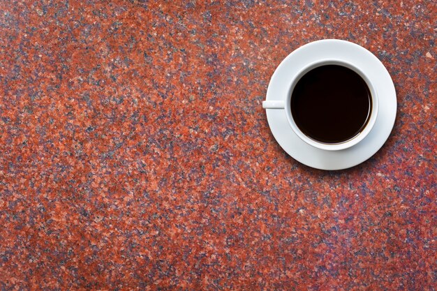 Sluit omhoog witte koffiekop op van de achtergrond steenlijst hoogste mening