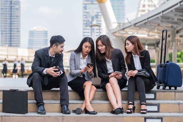 Sluit omhoog zittende zakenman en vrouw gebruikend slimme telefoon