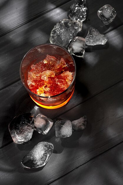 Slushies whiskey cocktail with ice on a black background with ice cubes