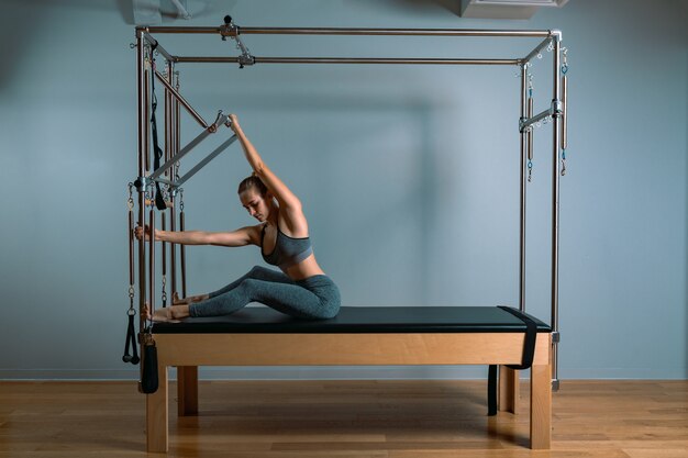 Smaakt trainer meisje poseren voor een hervormer in de sportschool. Fitness concept, speciale fitnessapparatuur, gezonde levensstijl, plastic