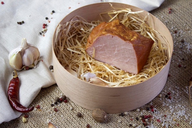 Smakelijk gebakken vlees met knoflook en kruiden in houten mand op ruwe linnenachtergrond close-up