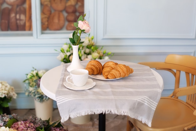 Smakelijk ontbijt kopje koffie met croissants in de buurt van bakkerij in de ochtend. Continentaal traditioneel ontbijt. Ontbijt in straatcafé. Goedemorgen. Ochtendkoffie op het terras. Ontbijt buiten. decor