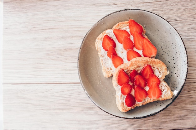 Smakelijk toostbrood met aardbeiplakken op houten achtergrond