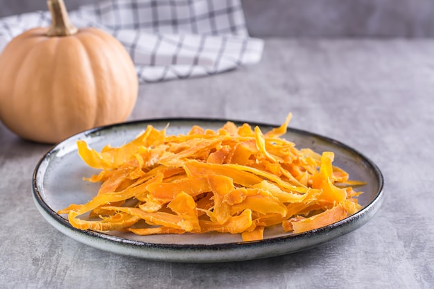 Smakelijk vegetarisch dessert pompoenchips op een bord op tafel