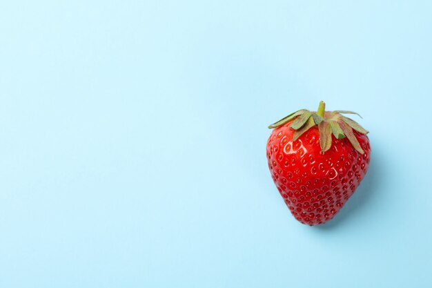 Smakelijke aardbei op blauwe achtergrond. Zomer bes