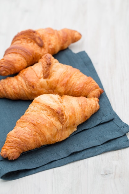 Smakelijke boterachtige croissants op oude houten tafel.