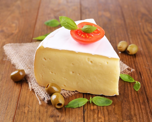 Smakelijke Camembertkaas met tomatenbasilicum en olijven op houten tafel