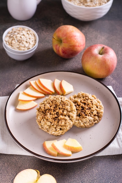 Smakelijke crumble van appels en havermout op een bord en fruit op tafel Verticaal zicht