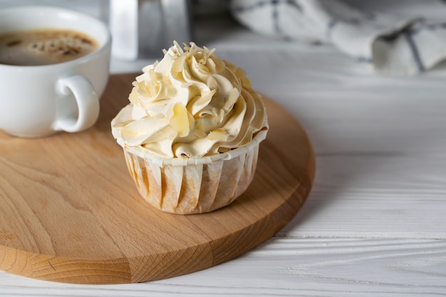 Smakelijke cupcake met amandelsmaak glazuur met kopje koffie