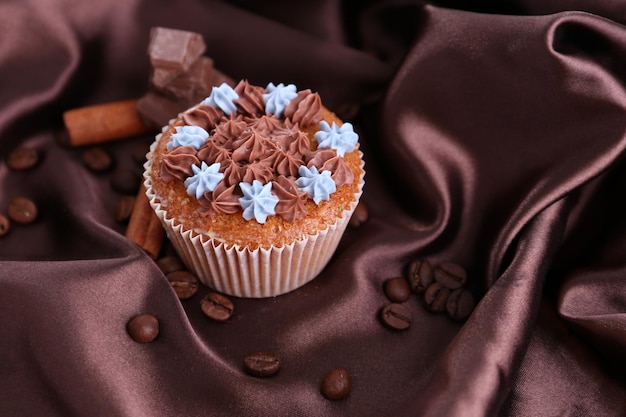 Smakelijke cupcake met boterroom op de achtergrond van de kleurenstof
