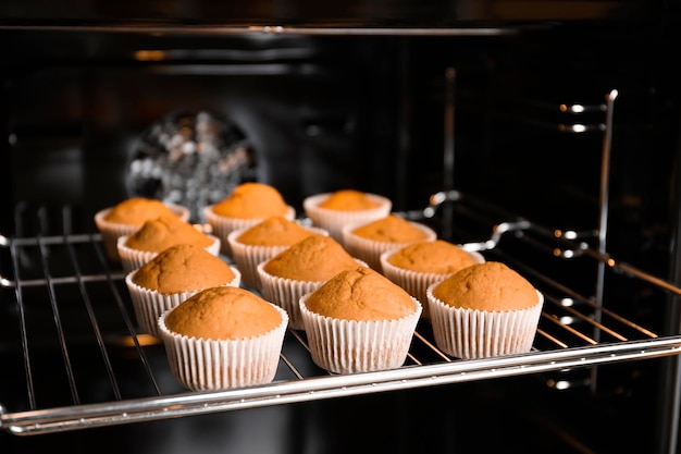 Smakelijke cupcakes op bakrek in de oven