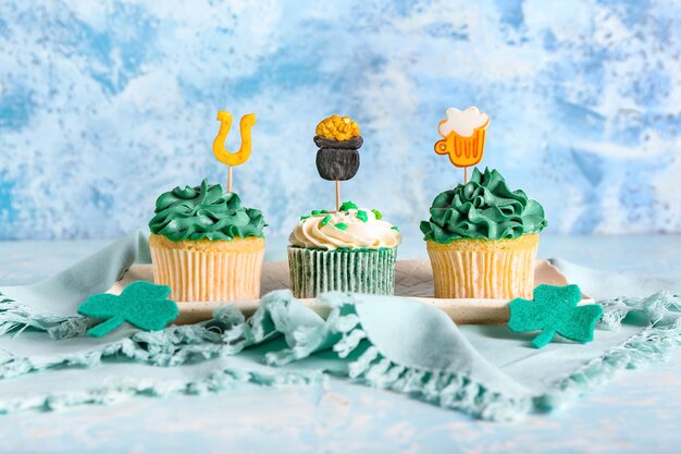 Smakelijke cupcakes voor St. Patrick's Day op kleur oppervlak