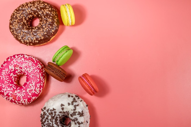 Smakelijke donuts en bitterkoekjes op roze achtergrond Bovenaanzicht kopie ruimte