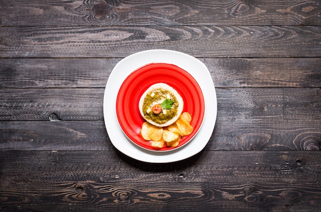 Smakelijke en heerlijke bruschetta met avocado, tomaten, kaas, kruiden, chips en sterke drank, op een houten achtergrond.