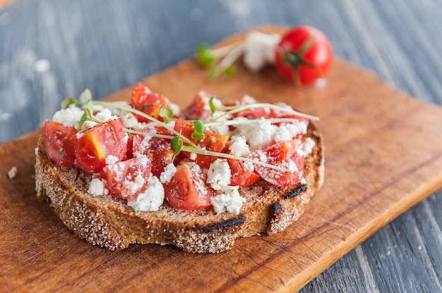 Smakelijke en heerlijke bruschetta met tomaten, spinazie, feta avocado rode chili peper en blauwe kaas.