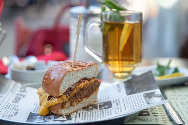 Smakelijke hamburger en een glas thee met citroen in een straatcafé