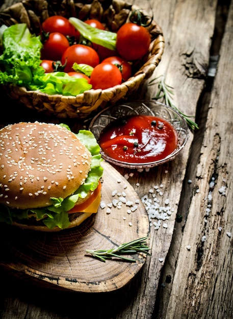 Smakelijke hamburger met saus op een houten bord. Op houten tafel.