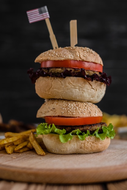 Smakelijke hamburger met vlees en groenten tegen een donkere achtergrond. Fast food. Het kan als achtergrond worden gebruikt