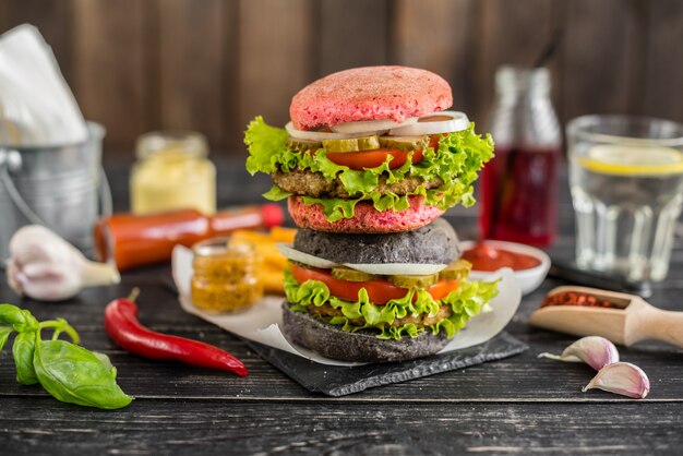 Smakelijke hamburger met vlees en groenten tegen een donkere achtergrond. Fast food. Het kan als achtergrond worden gebruikt