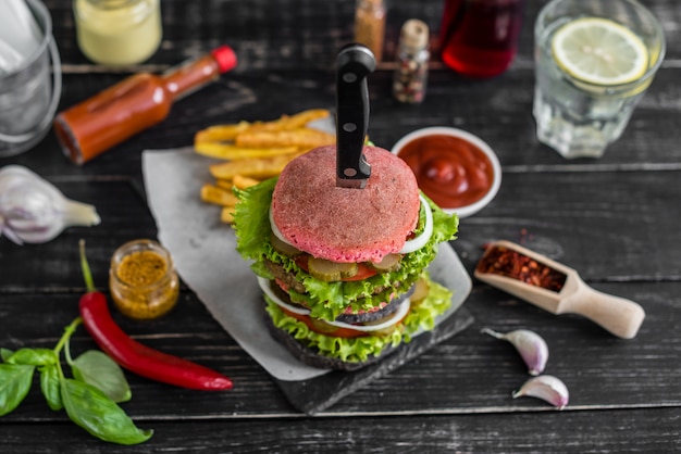 Smakelijke hamburger met vlees en groenten tegen een donkere achtergrond. Fast food. Het kan als achtergrond worden gebruikt