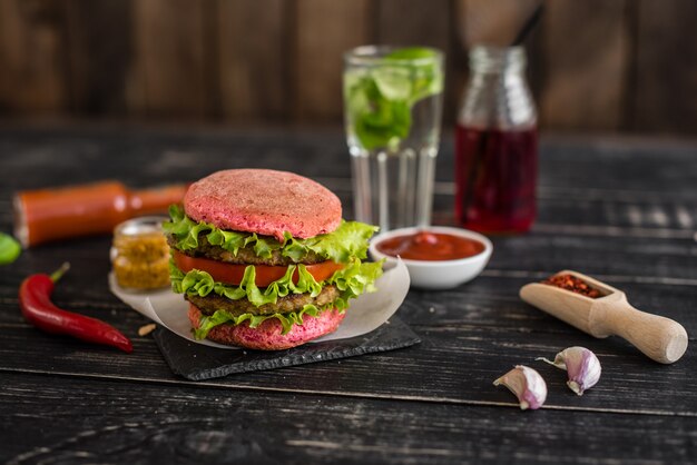 Smakelijke hamburger met vlees en groenten tegen een donkere achtergrond. Fast food. Het kan als achtergrond worden gebruikt