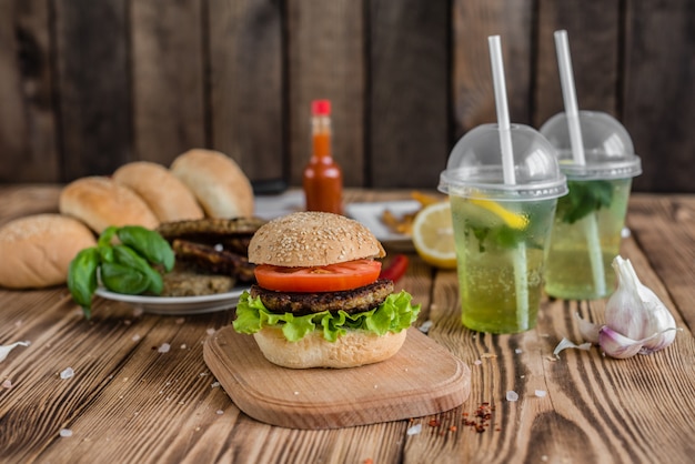 Smakelijke hamburger met vlees en groenten tegen een donkere achtergrond