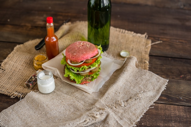 Smakelijke hamburger met vlees en groenten tegen een donkere achtergrond