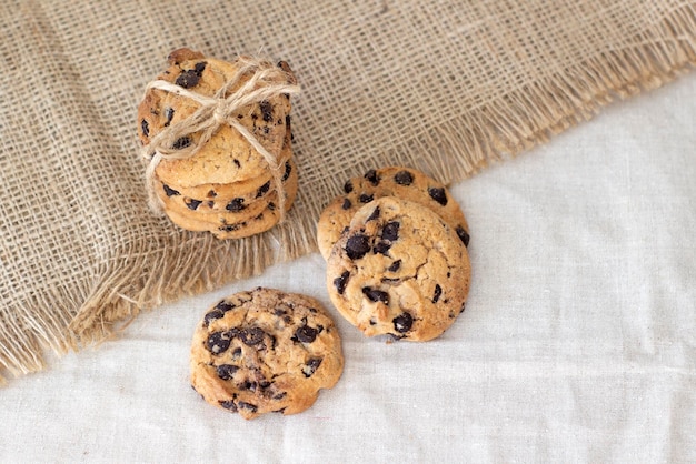 Smakelijke heerlijke koekjes met chocoladeschilfersclose-up op een ruwe linnenachtergrond