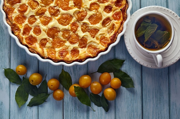 Smakelijke kersenpruimentaart op een blauw geverfde houten tafel