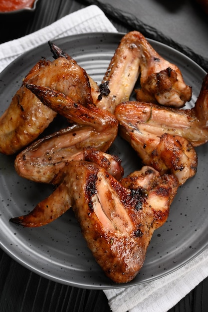 Foto smakelijke kippenvleugels gegrilde barbecue met kruiden en groenten tot ze knapperig zijn