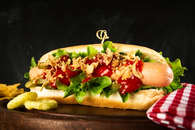 Smakelijke klassieke, traditionele amerikaanse hotdog met worstjes en ketchup op houten bord.