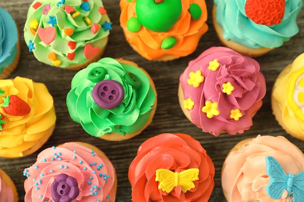 Smakelijke kleurrijke cupcakes op houten achtergrond