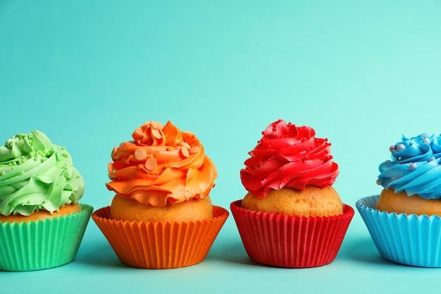 Foto smakelijke kleurrijke cupcakes op kleur achtergrond